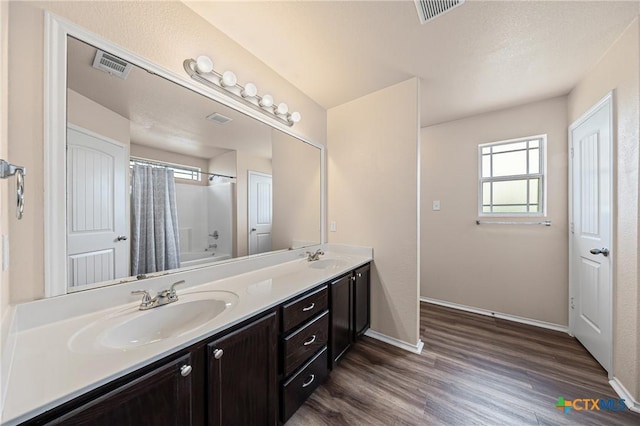 2007 Jefferson Ct, Belton, TX 76513 - bathroom featuring double vanity, wood finished floors, and shower / tub combo with curtain
