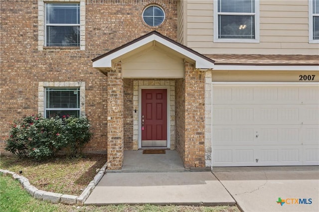 2007 Jefferson Ct, Belton, TX 76513 - doorway to property featuring a garage and brick siding