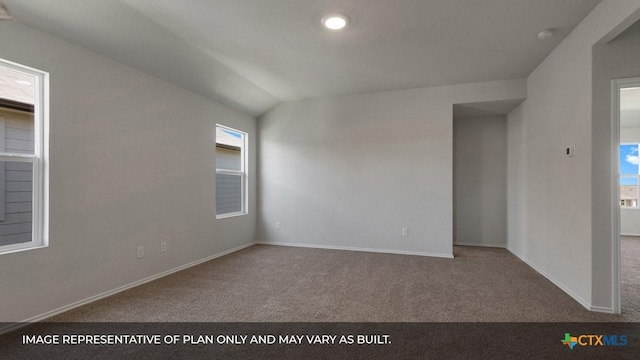 carpeted empty room featuring lofted ceiling