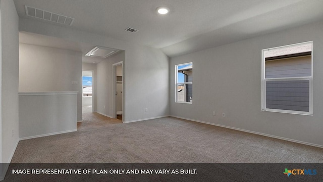 carpeted empty room featuring vaulted ceiling