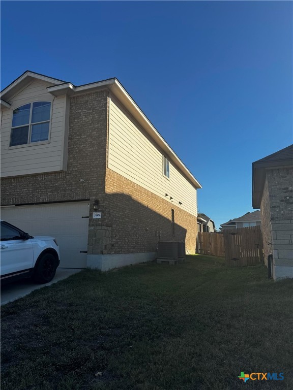 view of side of home with a yard and a garage