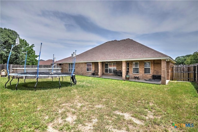 4813 Sapphire Dr, Killeen, TX 76542 - rear view of house featuring a trampoline, a patio, brick siding, and a shingled roof