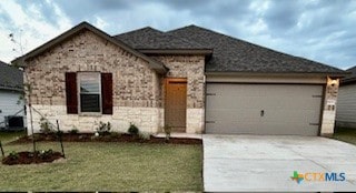 view of front of home featuring a garage and a front yard