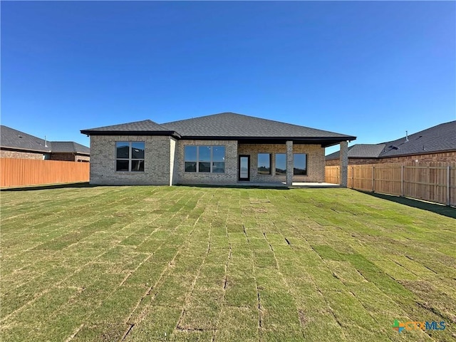 rear view of house featuring a lawn