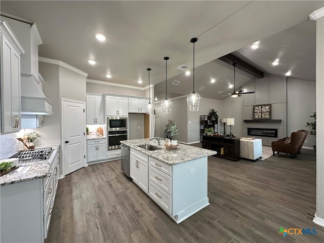 kitchen featuring white cabinetry, an island with sink, sink, light stone counters, and appliances with stainless steel finishes