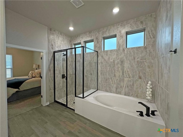 bathroom with separate shower and tub, tile walls, and hardwood / wood-style flooring