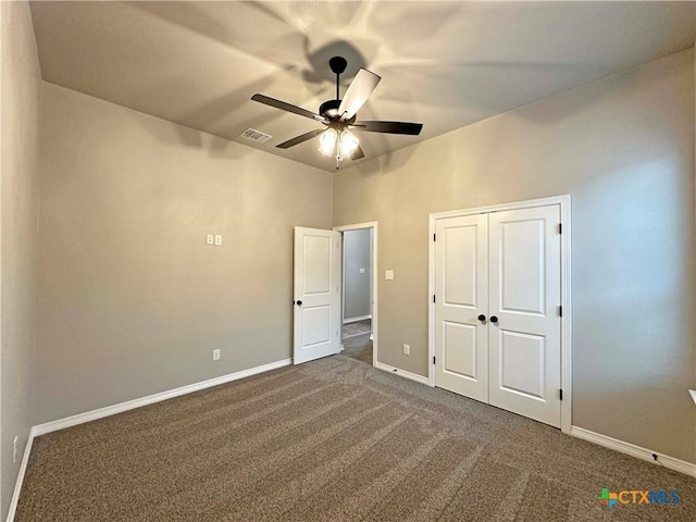 unfurnished bedroom featuring a closet, dark colored carpet, and ceiling fan