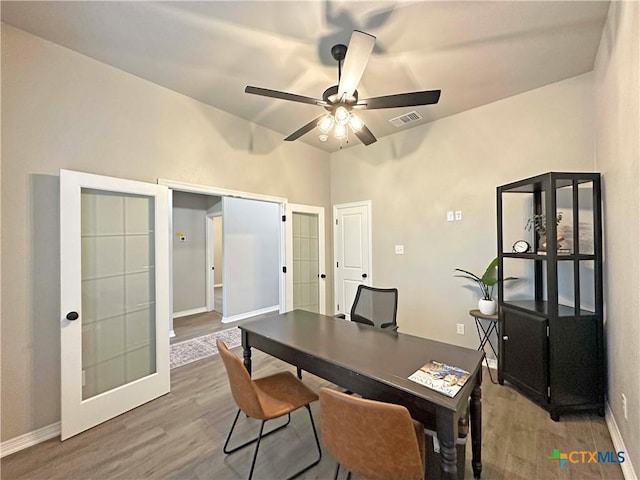 home office with ceiling fan, french doors, and wood-type flooring