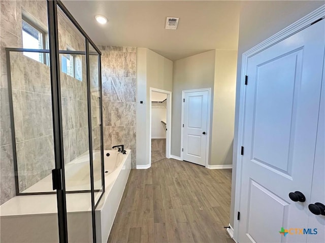 bathroom with hardwood / wood-style floors and separate shower and tub