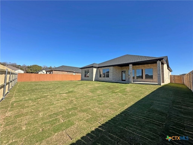 rear view of property with a yard