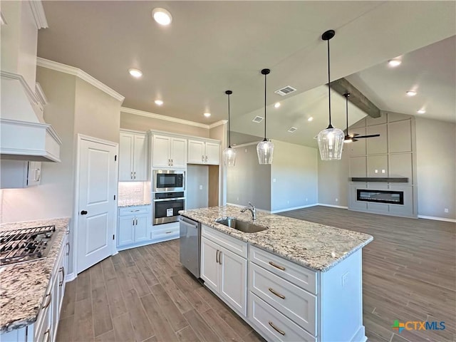 kitchen with white cabinetry, sink, hanging light fixtures, a center island with sink, and appliances with stainless steel finishes