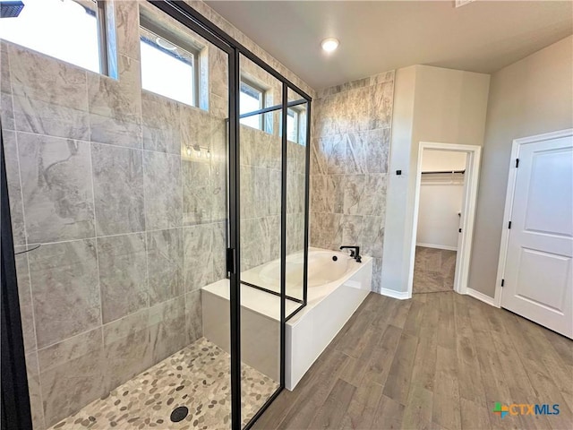 bathroom featuring shower with separate bathtub, a healthy amount of sunlight, and wood-type flooring