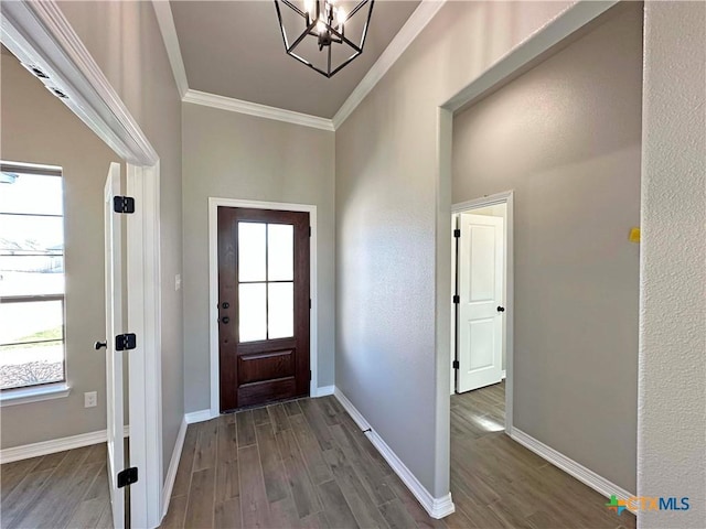 entryway featuring a chandelier, dark wood-type flooring, and crown molding