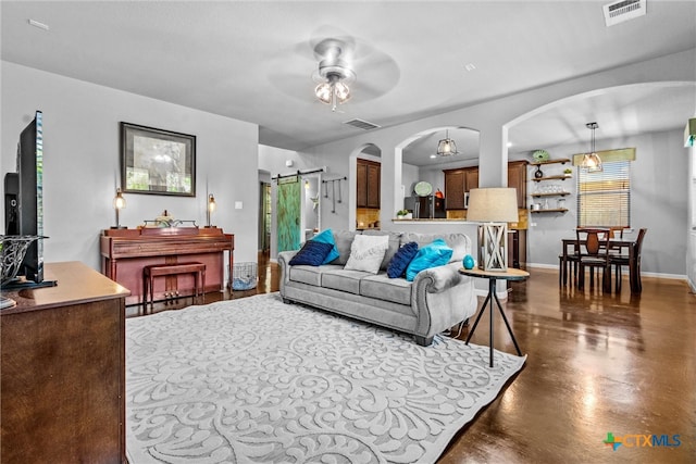 living room featuring a barn door and ceiling fan