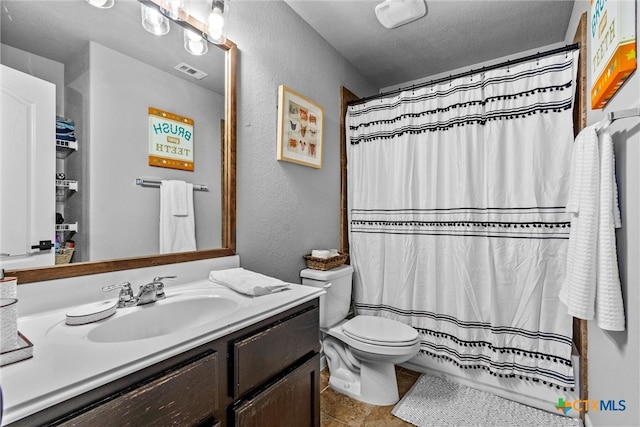 bathroom with vanity, tile patterned flooring, a shower with shower curtain, toilet, and a textured ceiling