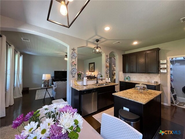 kitchen featuring dishwasher, sink, hanging light fixtures, light stone countertops, and a textured ceiling