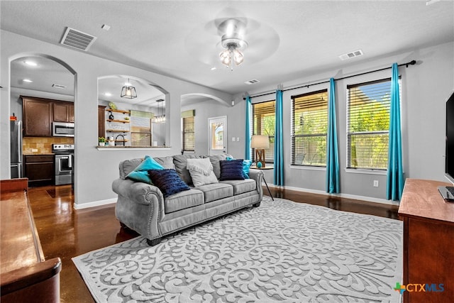 living room with ceiling fan and a textured ceiling