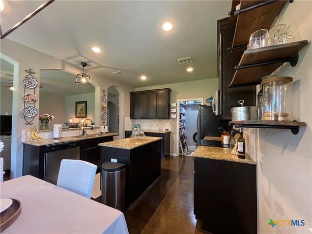 kitchen featuring pendant lighting, a kitchen island with sink, sink, tasteful backsplash, and stainless steel appliances