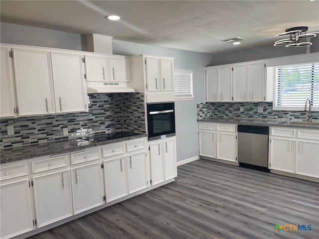 kitchen featuring white cabinetry, appliances with stainless steel finishes, and dark stone countertops