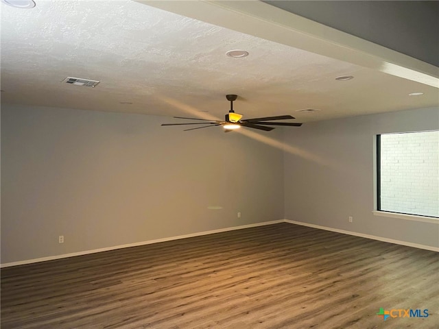 empty room featuring ceiling fan, dark hardwood / wood-style floors, and a textured ceiling