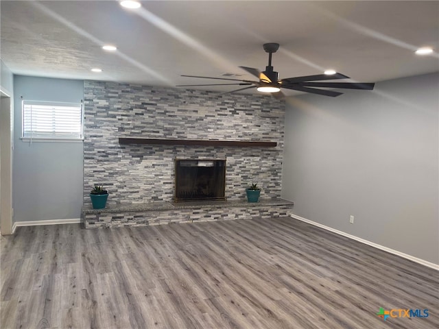 unfurnished living room with hardwood / wood-style floors, a fireplace, and ceiling fan