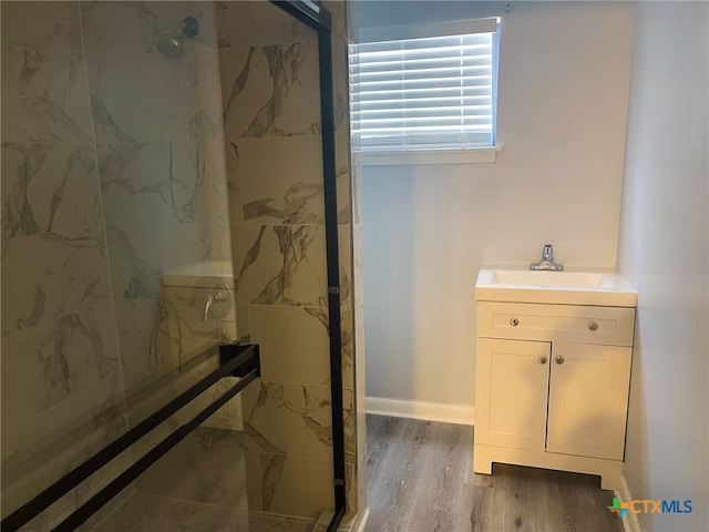 bathroom featuring tiled shower, hardwood / wood-style floors, and vanity