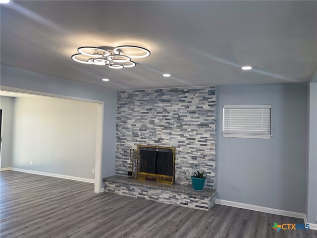 unfurnished living room featuring a fireplace and dark wood-type flooring