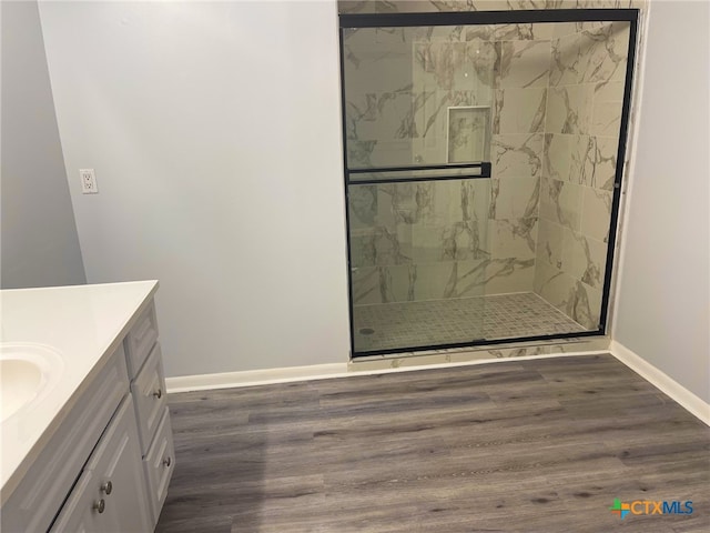 bathroom with an enclosed shower, vanity, and wood-type flooring