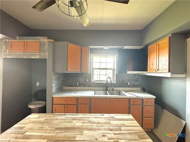 kitchen with decorative backsplash, ceiling fan, and sink