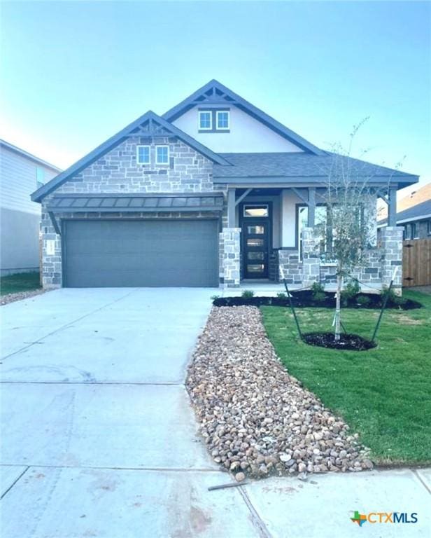 view of front of property featuring a front yard and a garage