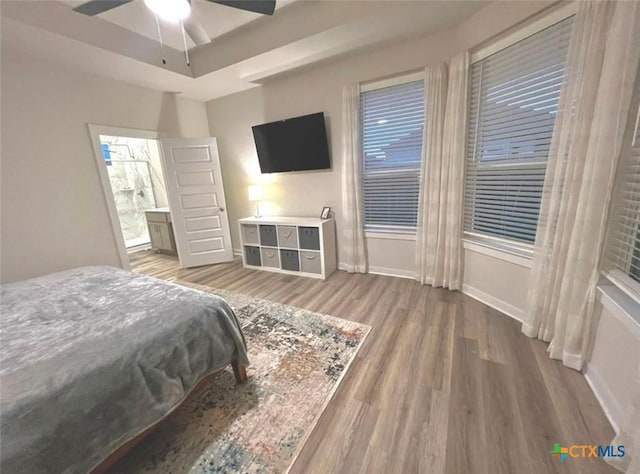 bedroom with ceiling fan, ensuite bath, and hardwood / wood-style flooring