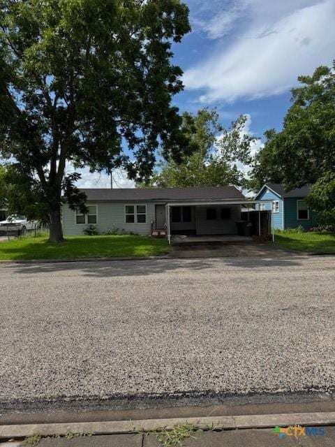 3205 Meadowlane St, Victoria, TX 77901 - view of front of property with asphalt driveway, a carport, and a front yard