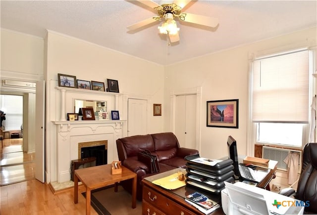 living room featuring ornamental molding, ceiling fan, and light hardwood / wood-style floors