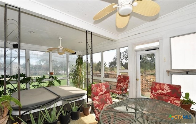 sunroom / solarium featuring ceiling fan and beam ceiling