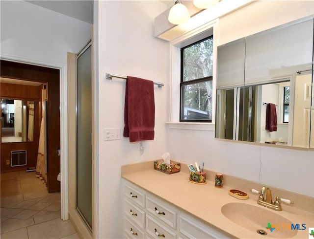 bathroom featuring tile patterned flooring, an enclosed shower, and vanity