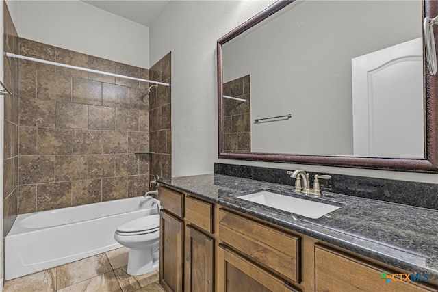 full bathroom featuring vanity, tiled shower / bath, and toilet