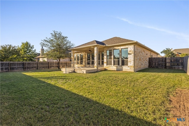 rear view of property featuring a lawn, a patio, and ceiling fan