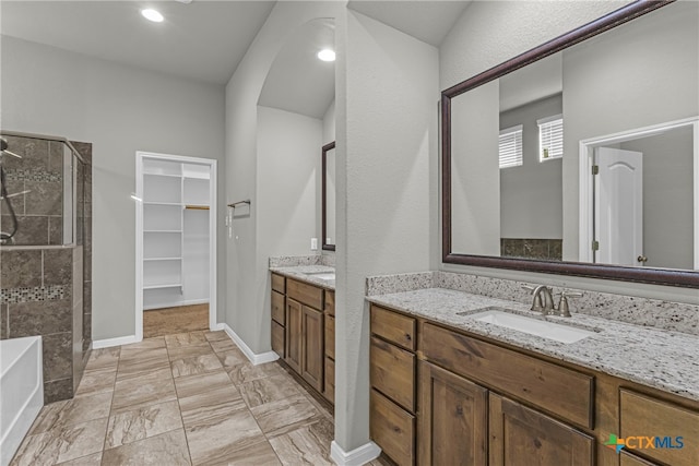 bathroom with vanity and independent shower and bath