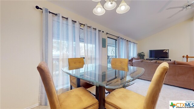 dining space featuring ceiling fan, vaulted ceiling, and light carpet