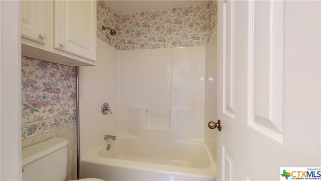 bathroom featuring toilet and washtub / shower combination