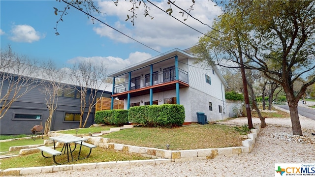 view of front of property with a front lawn and a balcony