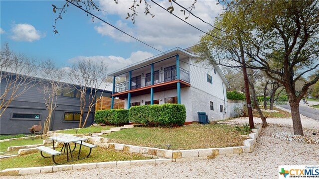 view of front of home featuring a front lawn and a balcony