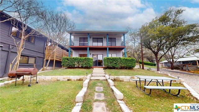 exterior space with a balcony and a front yard