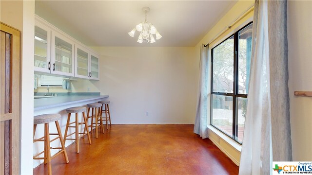 dining area with an inviting chandelier, a healthy amount of sunlight, and sink