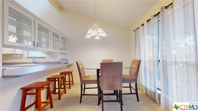 carpeted dining space featuring vaulted ceiling, a notable chandelier, and sink