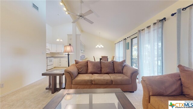 carpeted living room with high vaulted ceiling and ceiling fan with notable chandelier