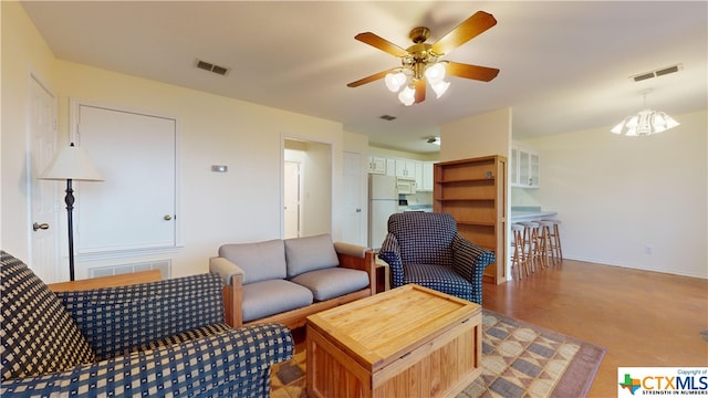 living room featuring ceiling fan with notable chandelier