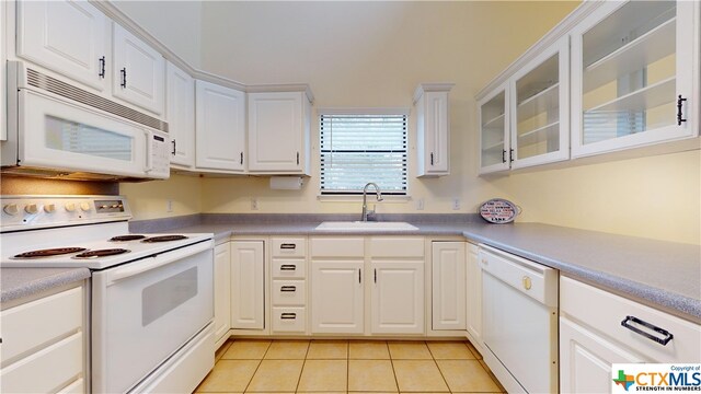 kitchen featuring light tile patterned floors, white cabinetry, sink, and white appliances