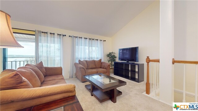 living room featuring light colored carpet and vaulted ceiling