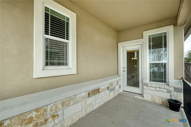 view of exterior entry with a patio